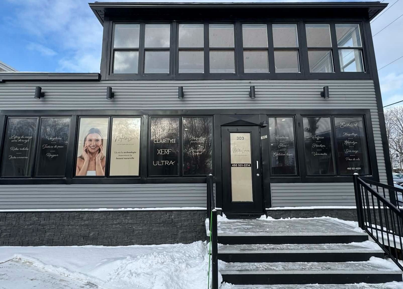 Entrée moderne de Naturel Skin à Granby, Québec, CA, avec fenêtres décorées et bâtiment gris.