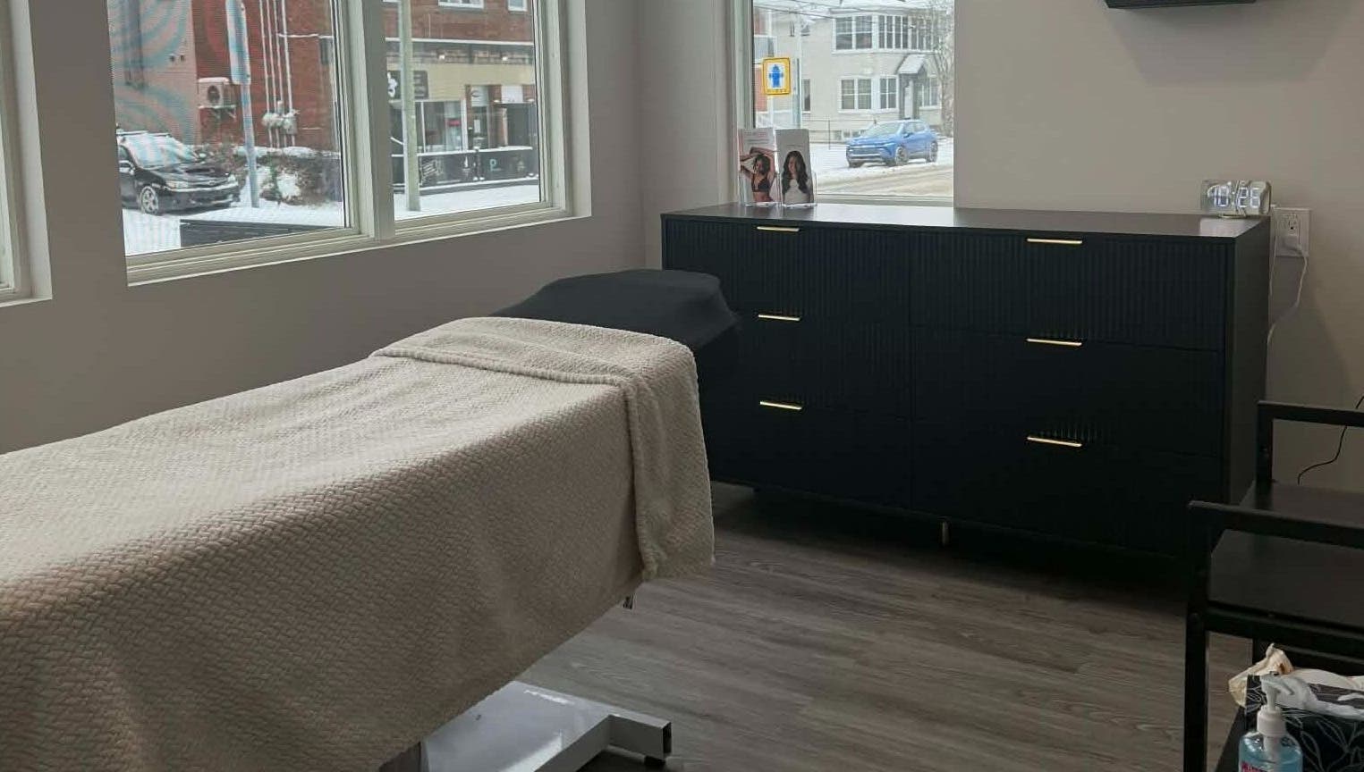 Salle de soin élégante chez Naturel Skin, Granby, Québec, CA, avec table de massage et grande fenêtre.