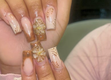 Intricate floral nail art at Nails by Frankie in Chicago, Illinois, US showcasing delicate brown designs.
