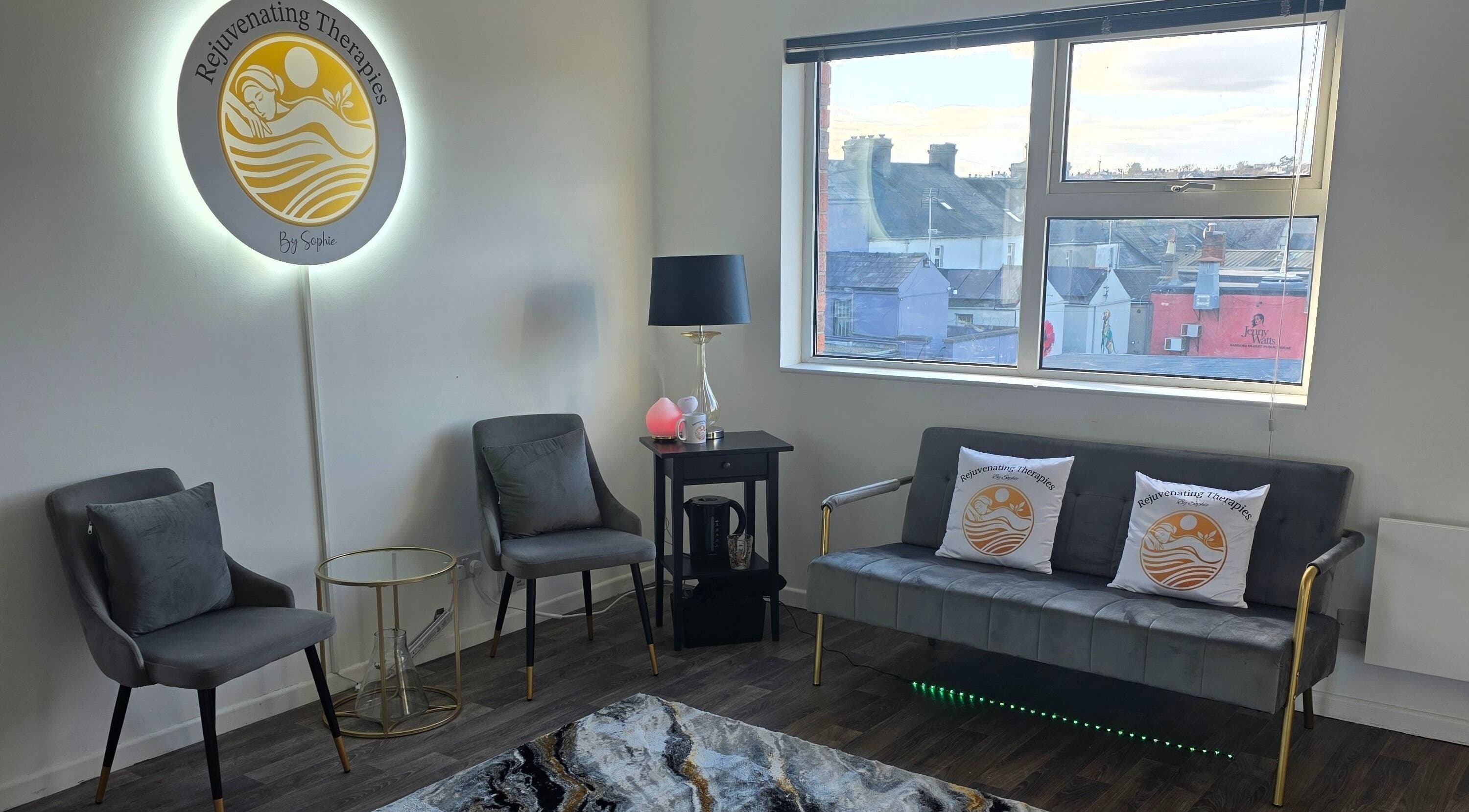 Cozy waiting area at Rejuvenating Therapies in Bangor, Northern Ireland, GB with chairs and branded pillows.