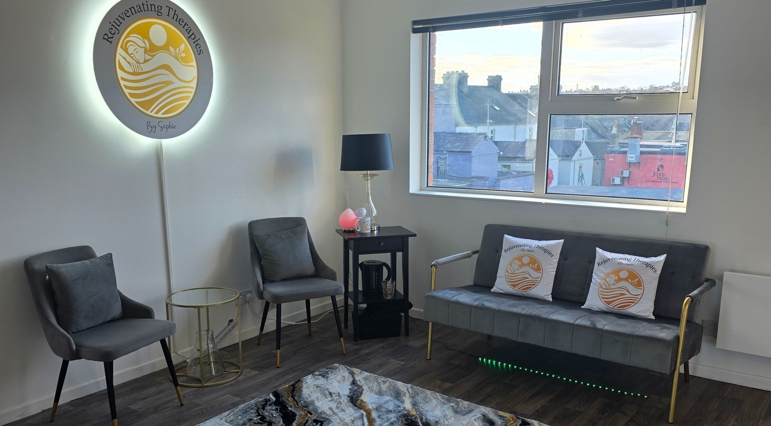 Cozy waiting area at Rejuvenating Therapies in Bangor, Northern Ireland, GB with chairs and branded pillows.