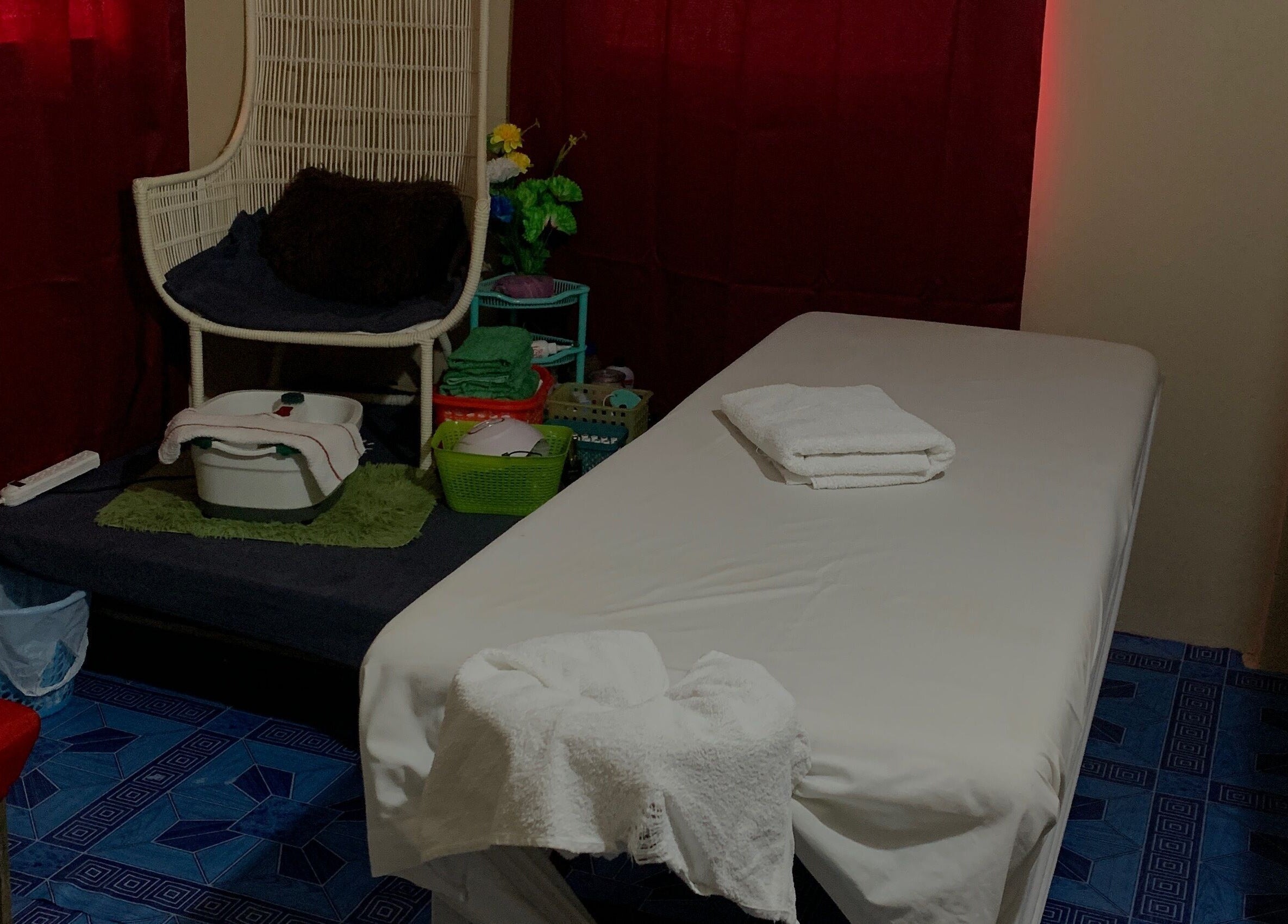 Relaxing treatment room at Glam Harmony Day Spa, Dennery, LC, featuring massage table and cozy chair.