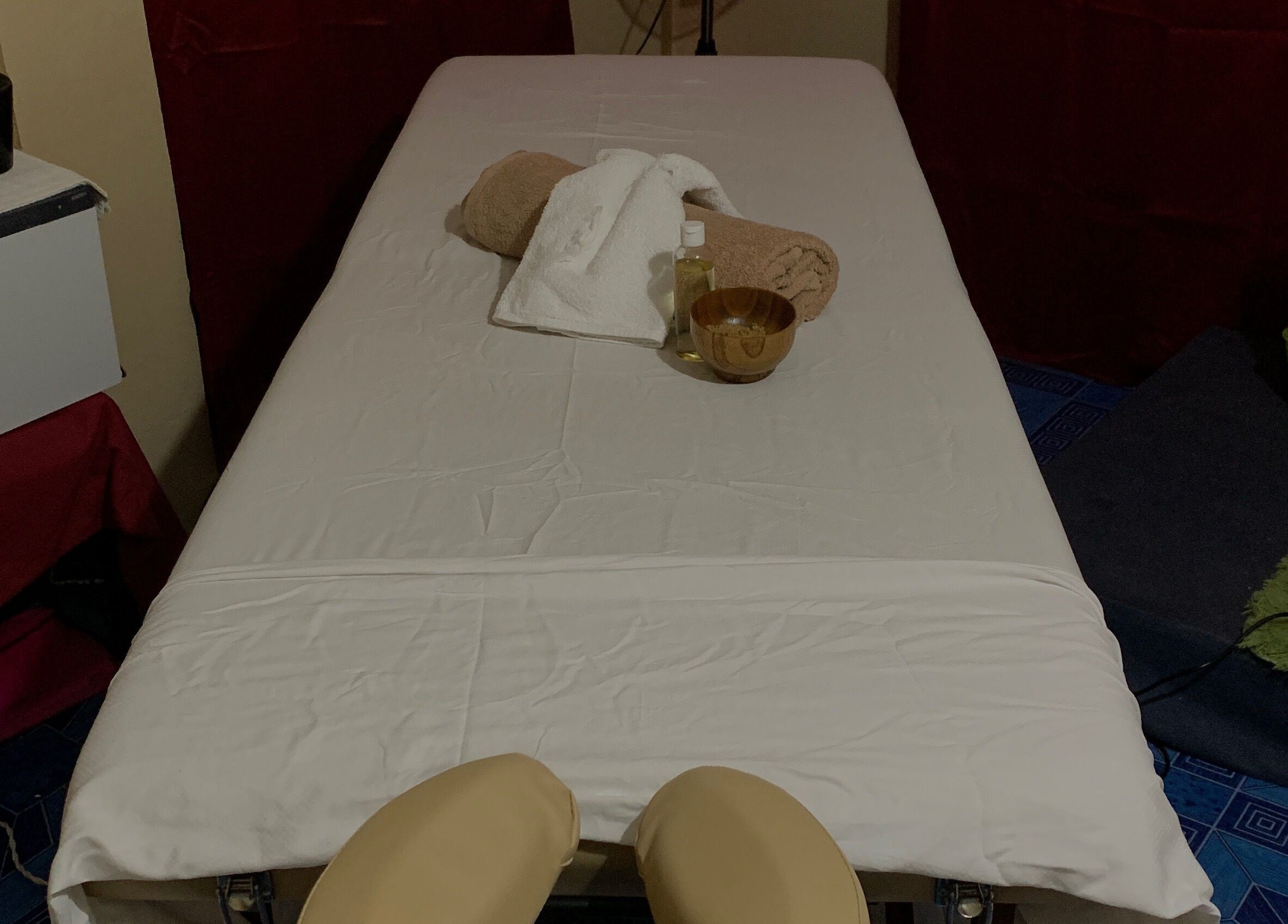 Relaxing massage table setup at Glam Harmony Day Spa, Dennery, LC, with towels and oil.