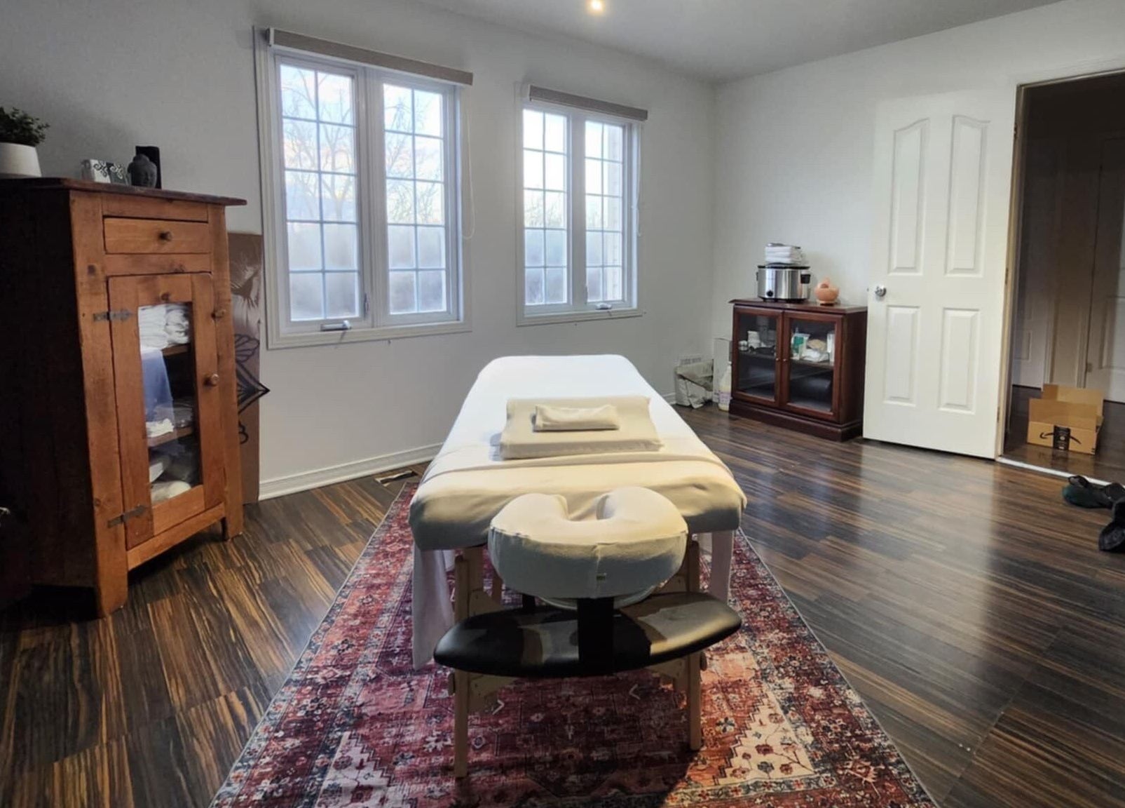 Cozy massage room at Aylmer / Plateau, Gatineau, Québec, CA with a wooden cabinet and soothing decor.