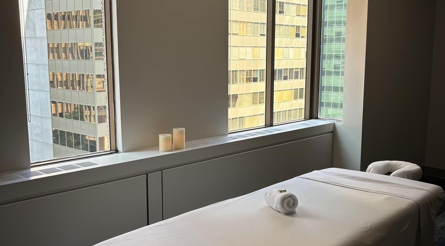 Relaxing massage room at Massothérapie Amanda Côté in Gatineau, Québec, CA with natural light and candles.