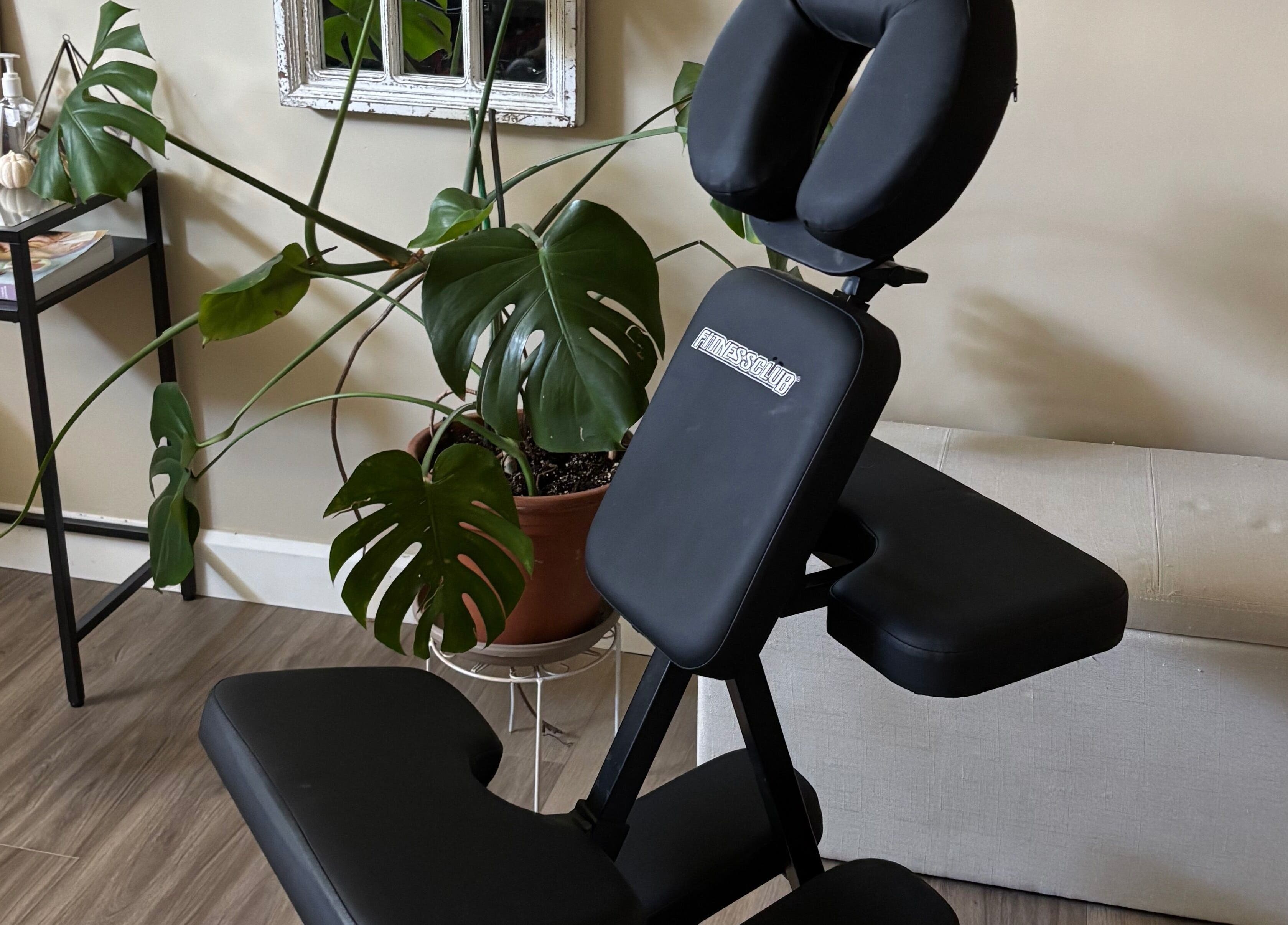 Massage chair and lush plant at Massothérapie Amanda Côté, Gatineau, Québec, CA, offering serene wellness.