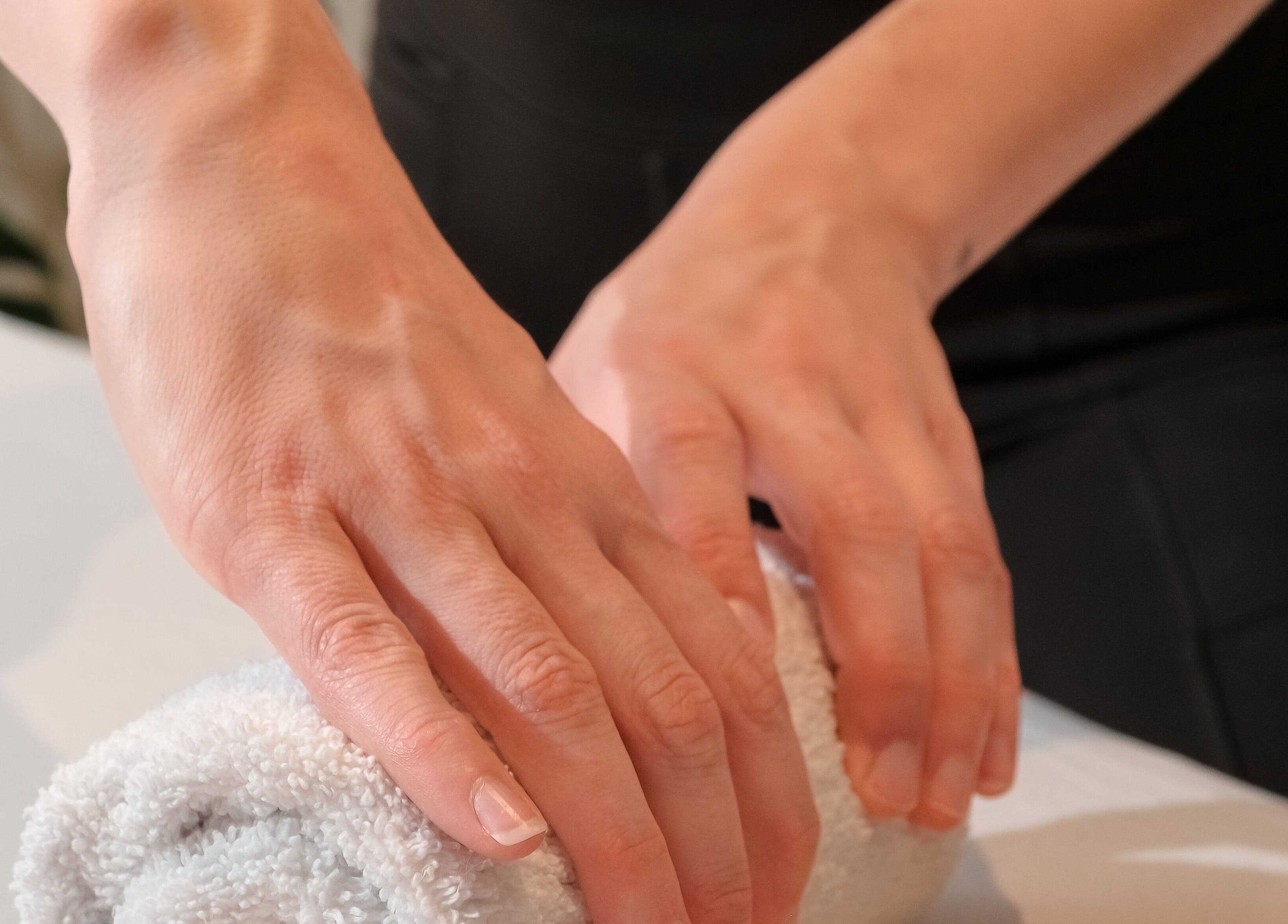 Hands preparing a towel at Massothérapie Amanda Côté, Gatineau, Québec, CA, symbolizing quality care.