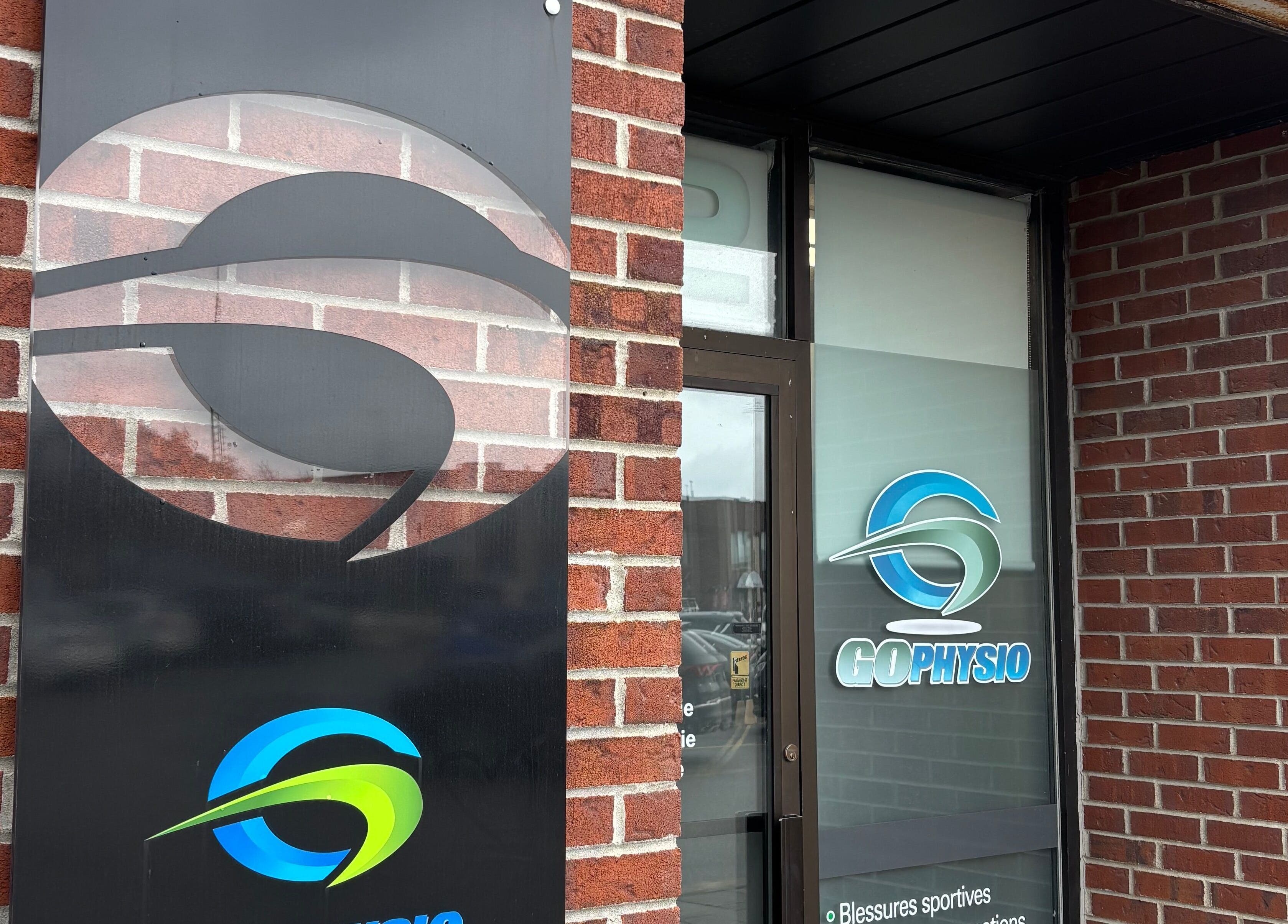 Entrance to GoPhysio, Sporthèque Jean Proulx, Gatineau, Québec, CA with logo on brick wall.