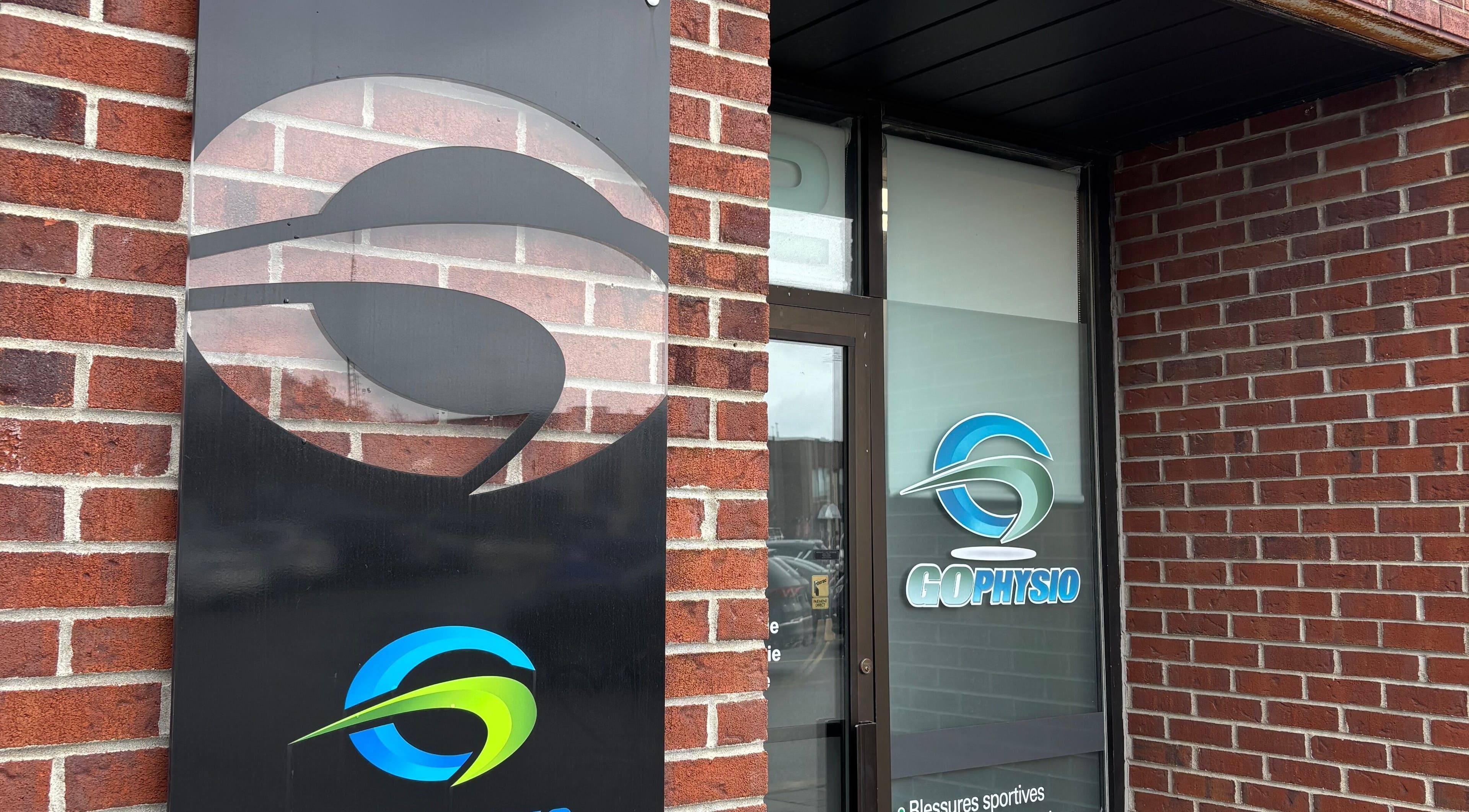 Entrance to GoPhysio, Sporthèque Jean Proulx, Gatineau, Québec, CA with logo on brick wall.