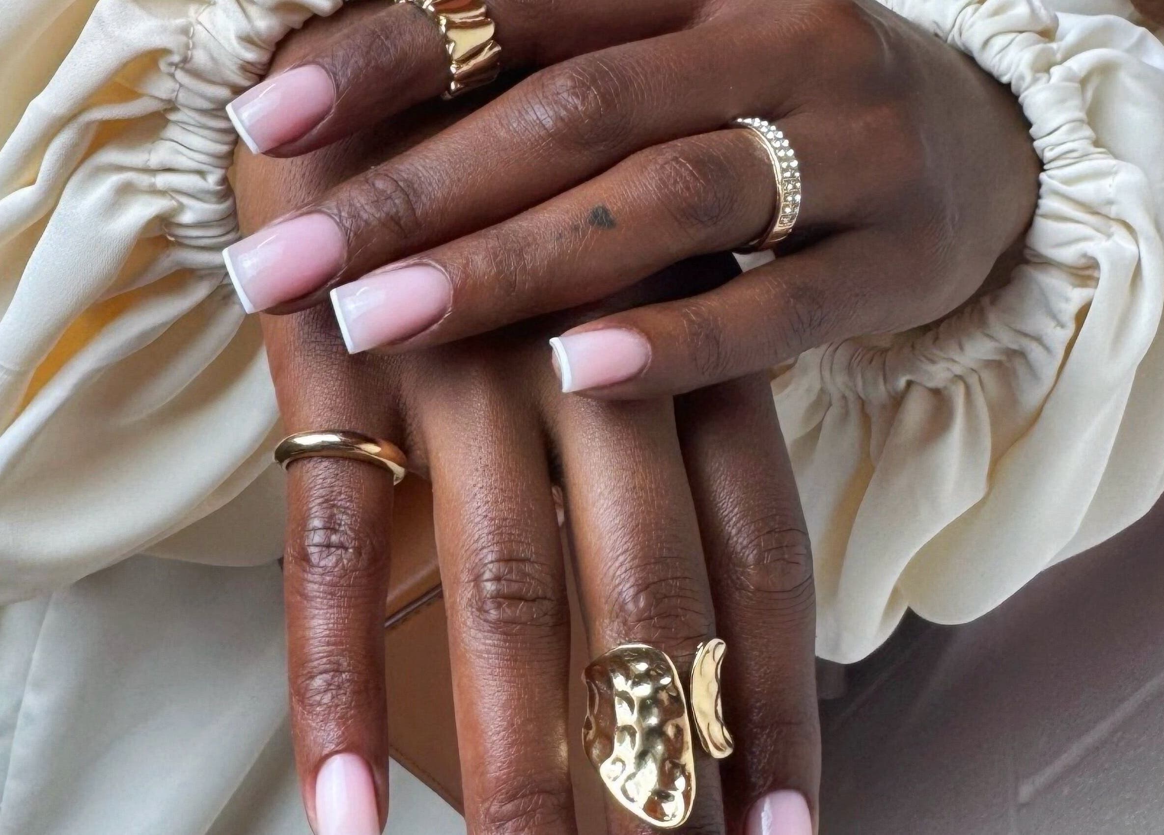 Stylish French manicure with gold rings at Maria Benitez Nails Studio, Rosebery, New South Wales, AU.