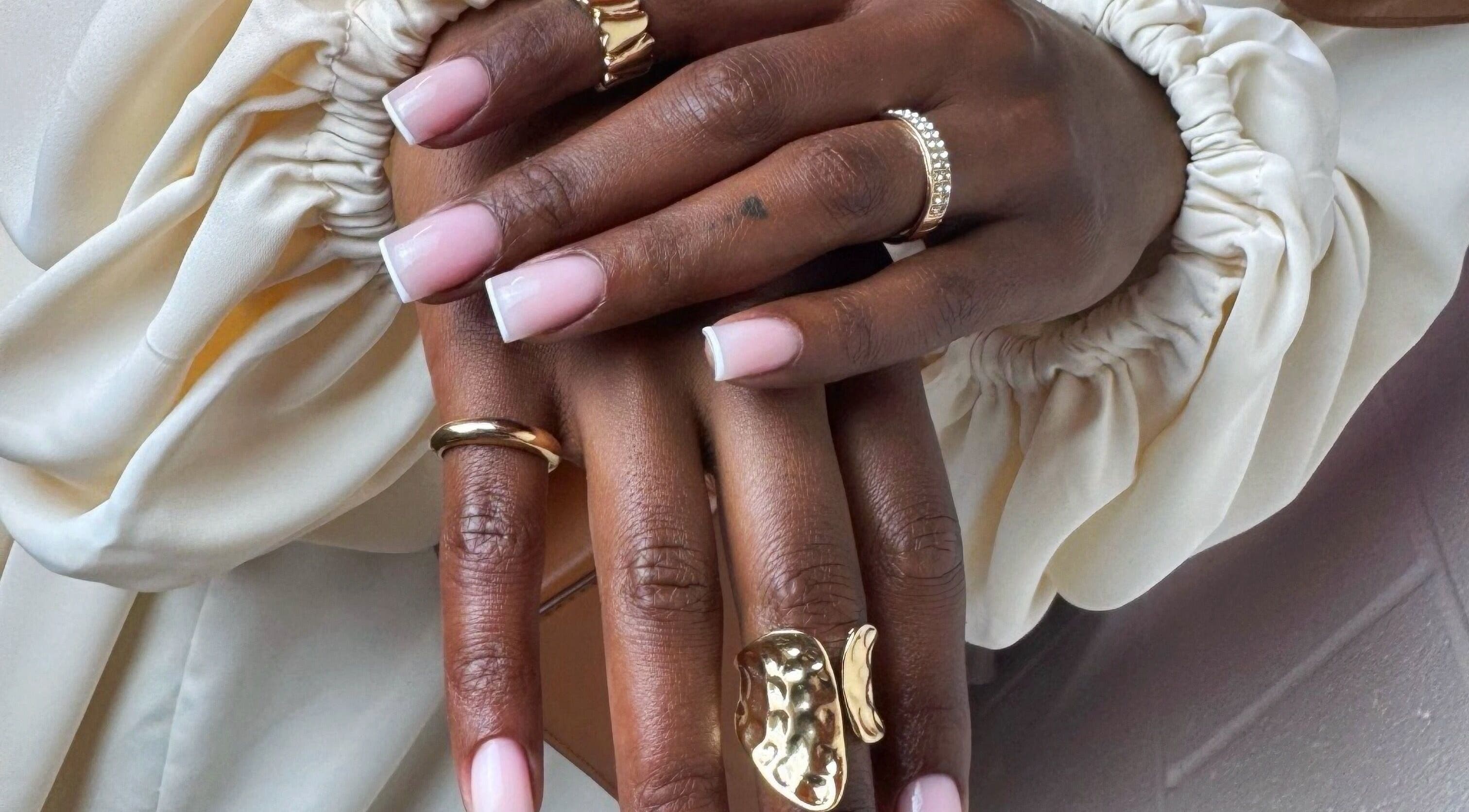 Stylish French manicure with gold rings at Maria Benitez Nails Studio, Rosebery, New South Wales, AU.