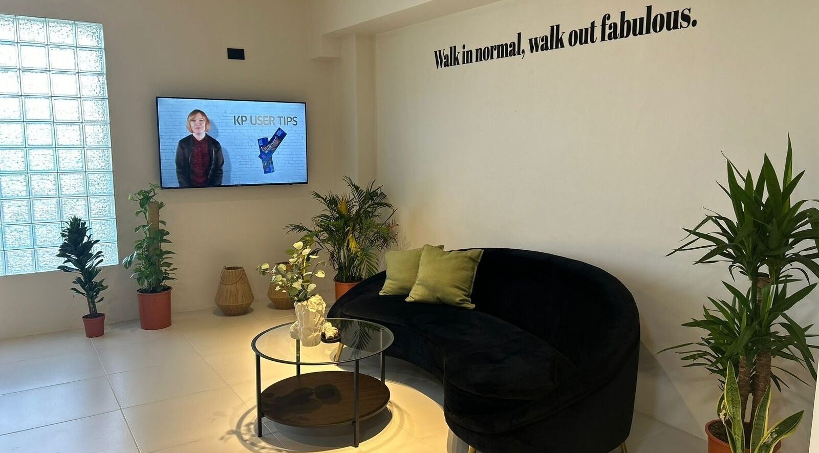 منطقة استقبال أنيقة في صالون سيج، الدمام، المنطقة الشرقية، السعودية مع أريكة فاخرة ونباتات.