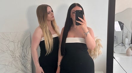 Two women at Aesthetic Affairs, Leicester, England, GB, pose stylishly in front of a mirror.