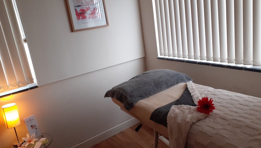 Cozy treatment room at Malvern Hills Beauty, Malvern, England, GB with massage bed and soft lighting.