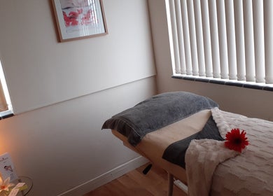Cozy treatment room at Malvern Hills Beauty, Malvern, England, GB with massage bed and soft lighting.