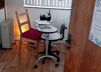 Relaxing beauty treatment room at Malvern Hills Beauty, Malvern, England, GB, with wood floor and cozy lighting.