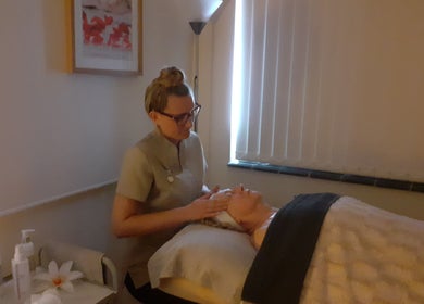 Aesthetician offers a calming facial treatment at Malvern Hills Beauty in Malvern, England, GB.