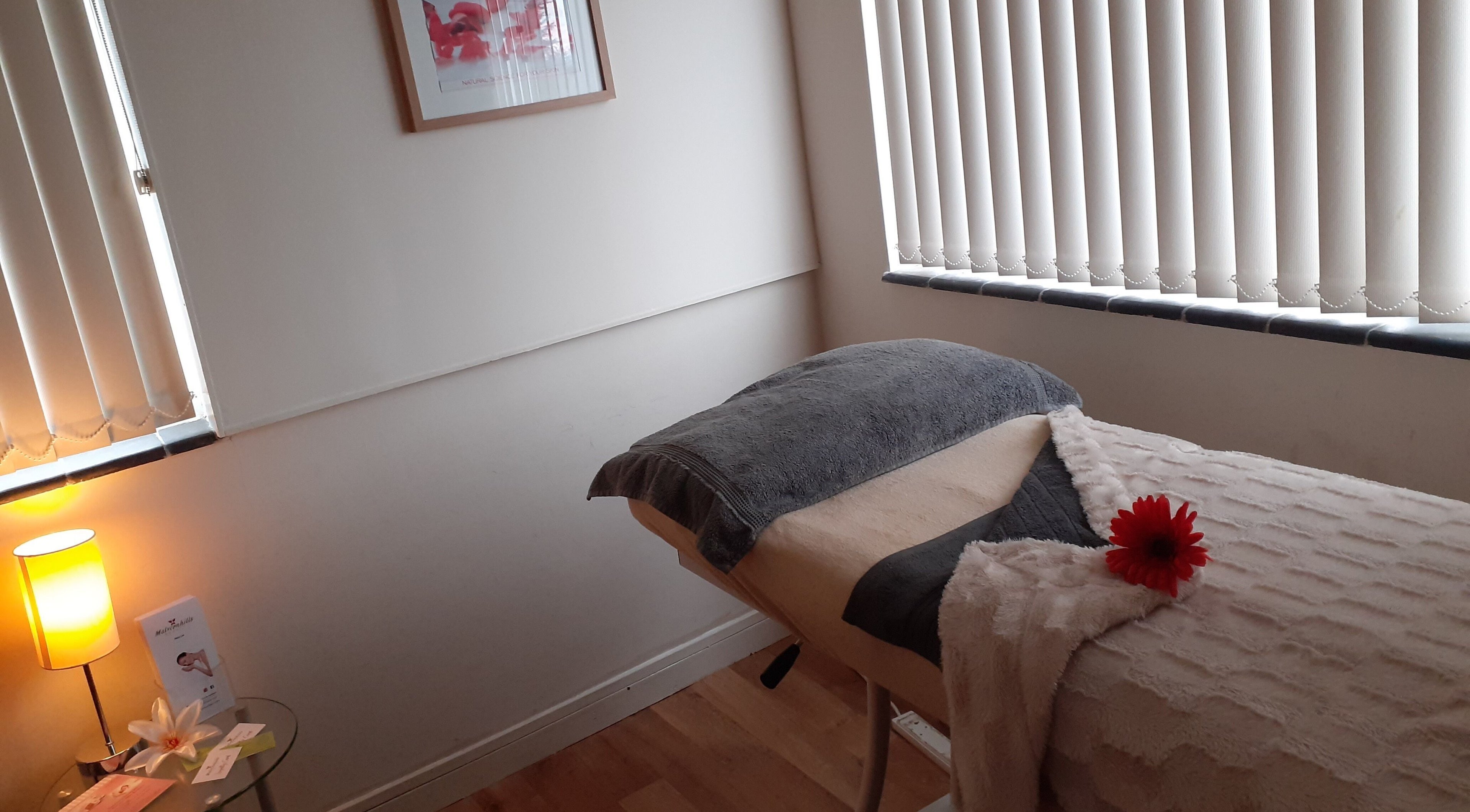 Serene massage room at Malvern Hills Beauty, Malvern, England, GB with a cozy bed and soft lighting.