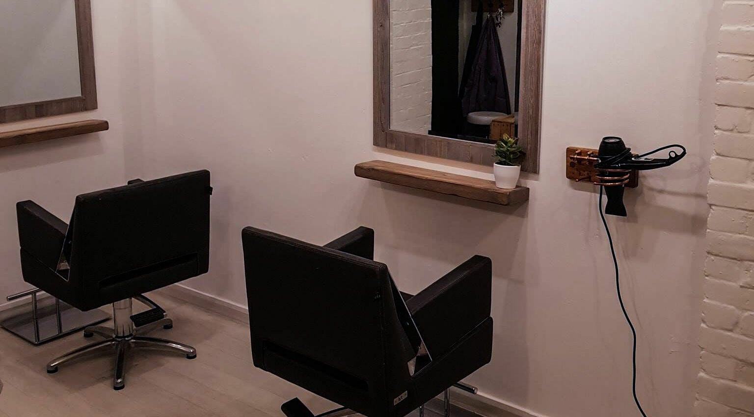 Modern salon chairs at Puro Hair, Petersfield, England, GB, showcasing a sleek, minimalist design.