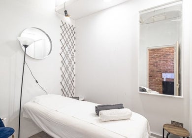 The Spa Culture's serene treatment room in London, England, GB with massage bed, mirror, and calming decor.