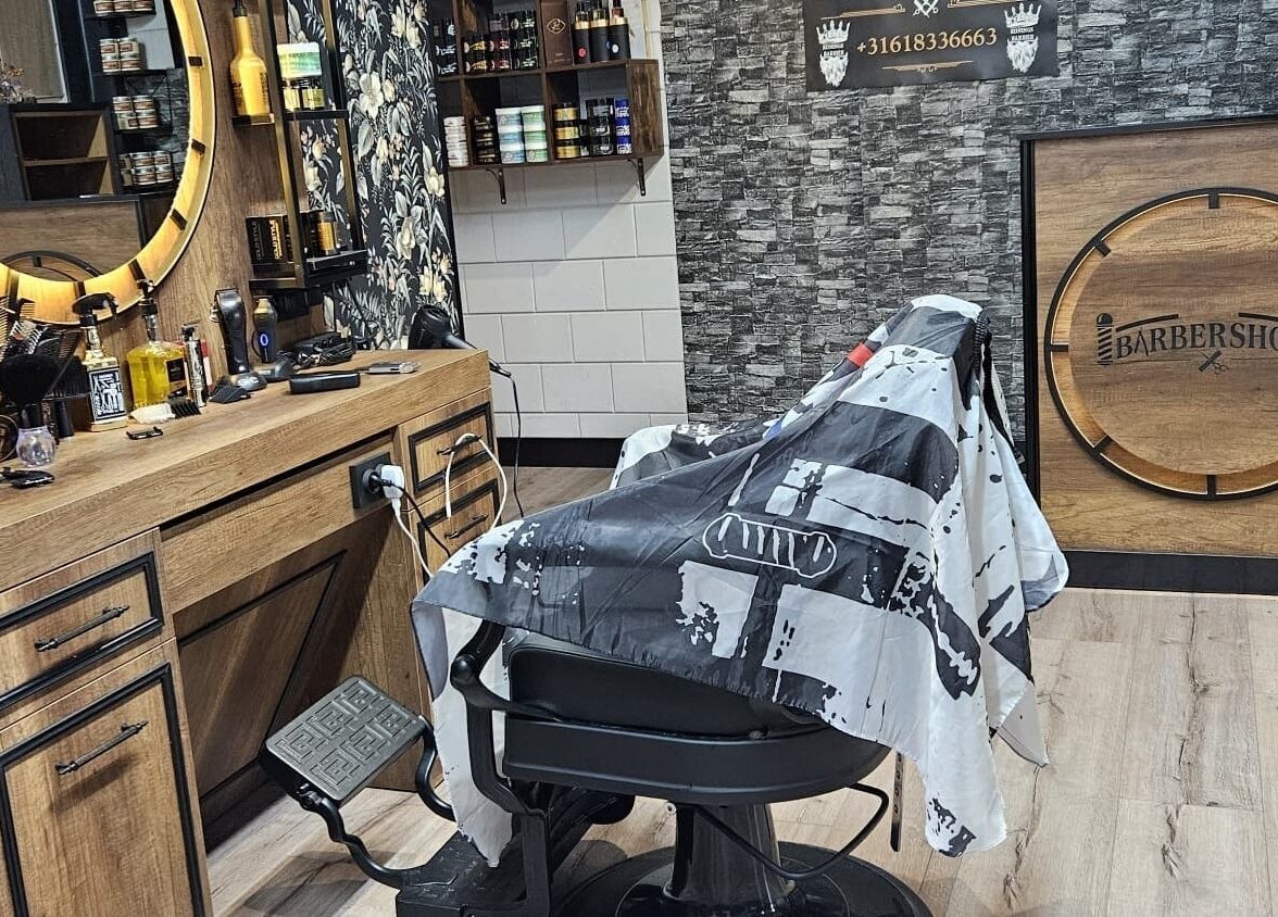 Interieur van Konings Barbier, Zevenhuizen, Zuid-Holland, NL met stijlvolle houten meubels en kappersstoel.