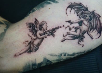 Unique cherub gun tattoo at Z A Tattoo, Bolton, England, GB showcasing artistic detail.