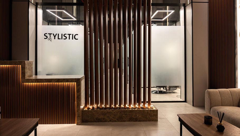 مدخل حديث لصالون Stylistic Barbershop في الرياض، منطقة الرياض، SA مع تفاصيل خشبية وإضاءة دافئة.