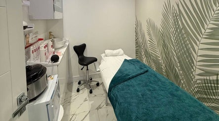 Treatment room at Glam Haus Clinic, Coventry, England, GB with modern decor and tropical wall design.