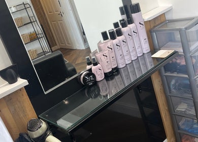 Professional hair products displayed at Hairbycjay salon in Leigh, England, GB, showcasing sleek decor.