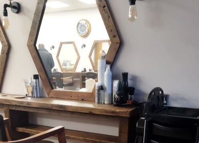 Stylish hair salon interior at Hair by Aneta with hexagonal mirrors in Grimsby, England, GB.