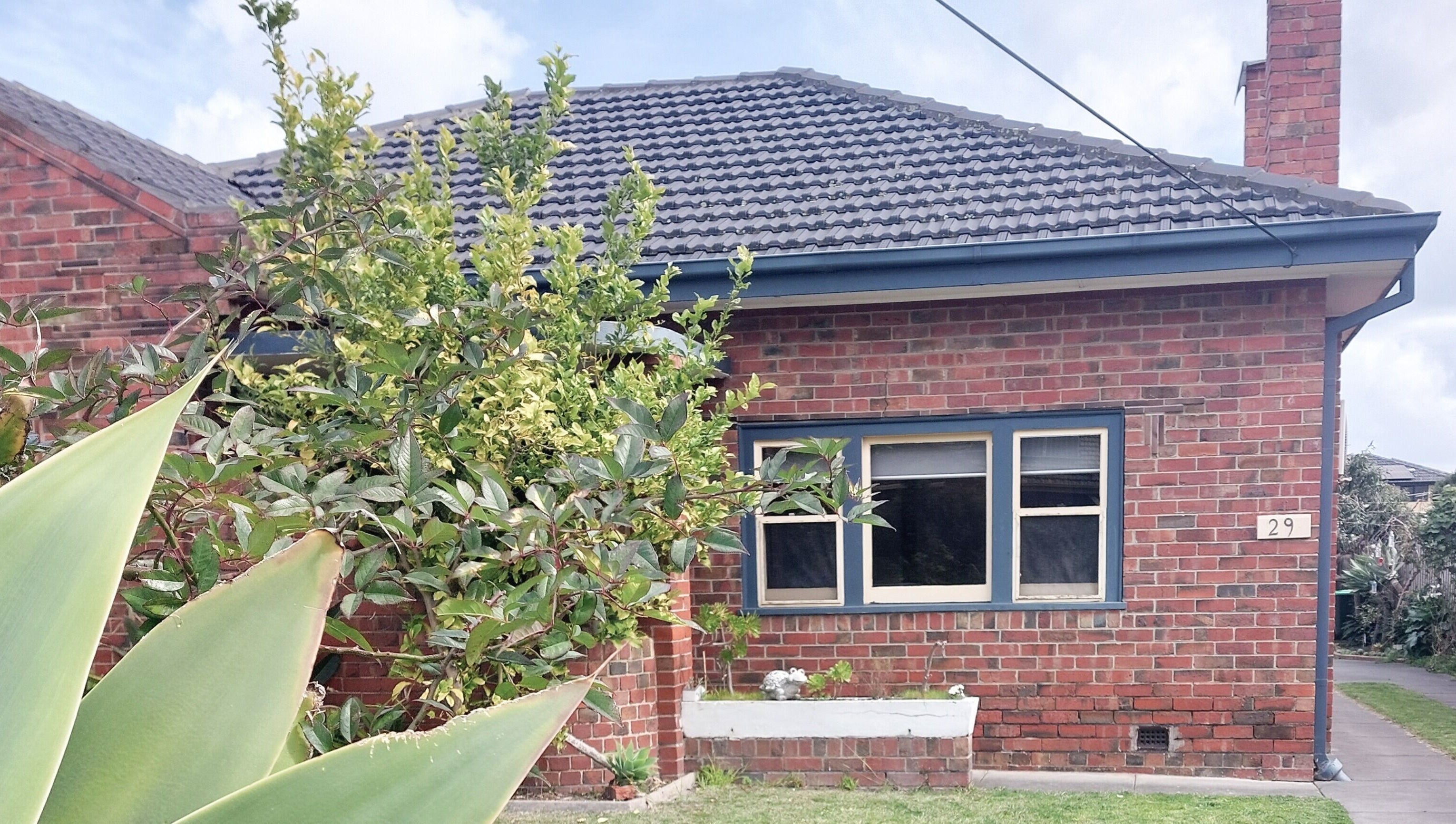 Charming brick facade of Facial Healing Co. nestled in lush greenery at Ormond, Victoria, AU.