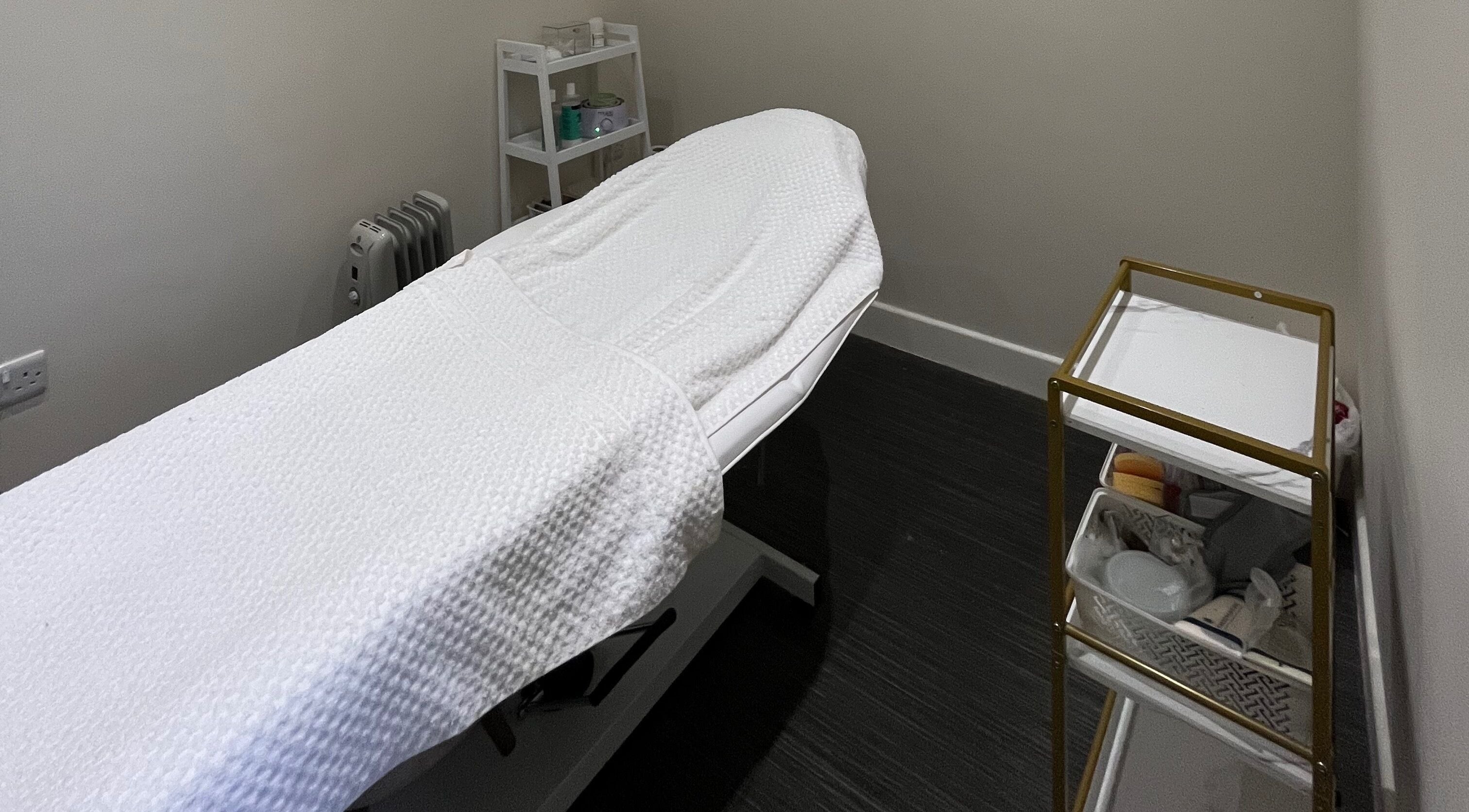 Relaxing treatment room at The Beauty Base by Cara, Ashbourne, England, GB featuring a white massage table.