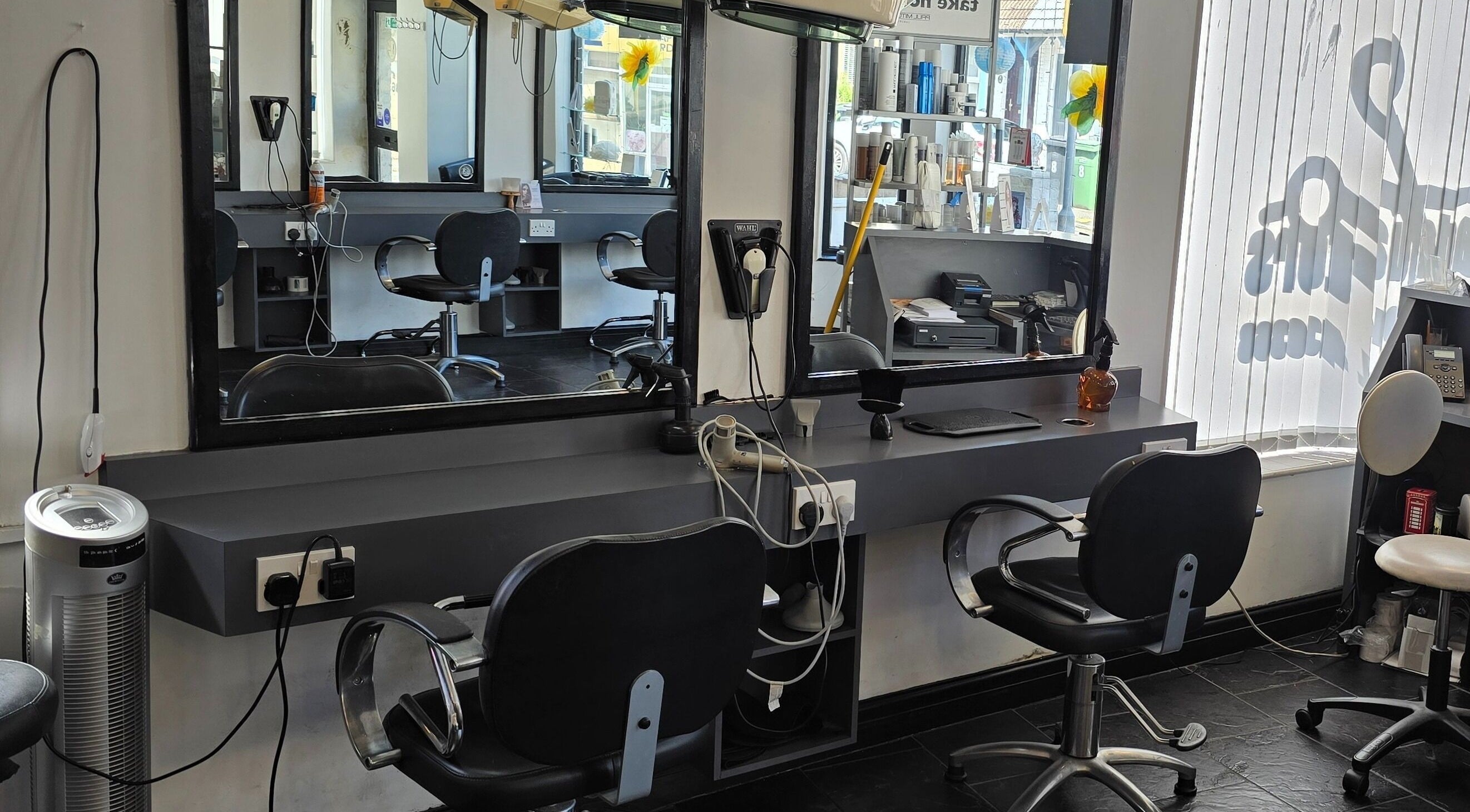 Modern salon interior at Headquarters, Hastings, England, GB. Features styling chairs, mirrors, and equipment.