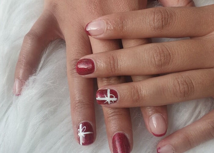 Close-up of elegant nail art at OM Nail Design, Dublin, County Dublin, IE. Red and pink nails with white designs.