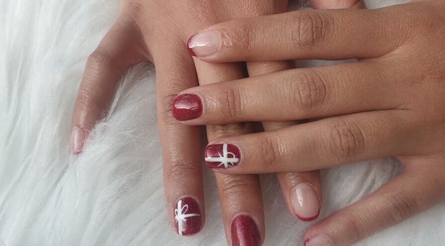 Close-up of elegant nail art at OM Nail Design, Dublin, County Dublin, IE. Red and pink nails with white designs.