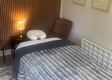 Cozy therapy room at Woodview Holistic Therapies, Sheffield, England, GB with a plush bed and ambient lighting.