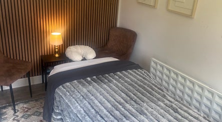 Cozy therapy room at Woodview Holistic Therapies, Sheffield, England, GB, with plush bed and warm lighting.