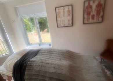 Cozy therapy room at Woodview Holistic Therapies, Sheffield, England, GB, featuring a treatment bed and window view.