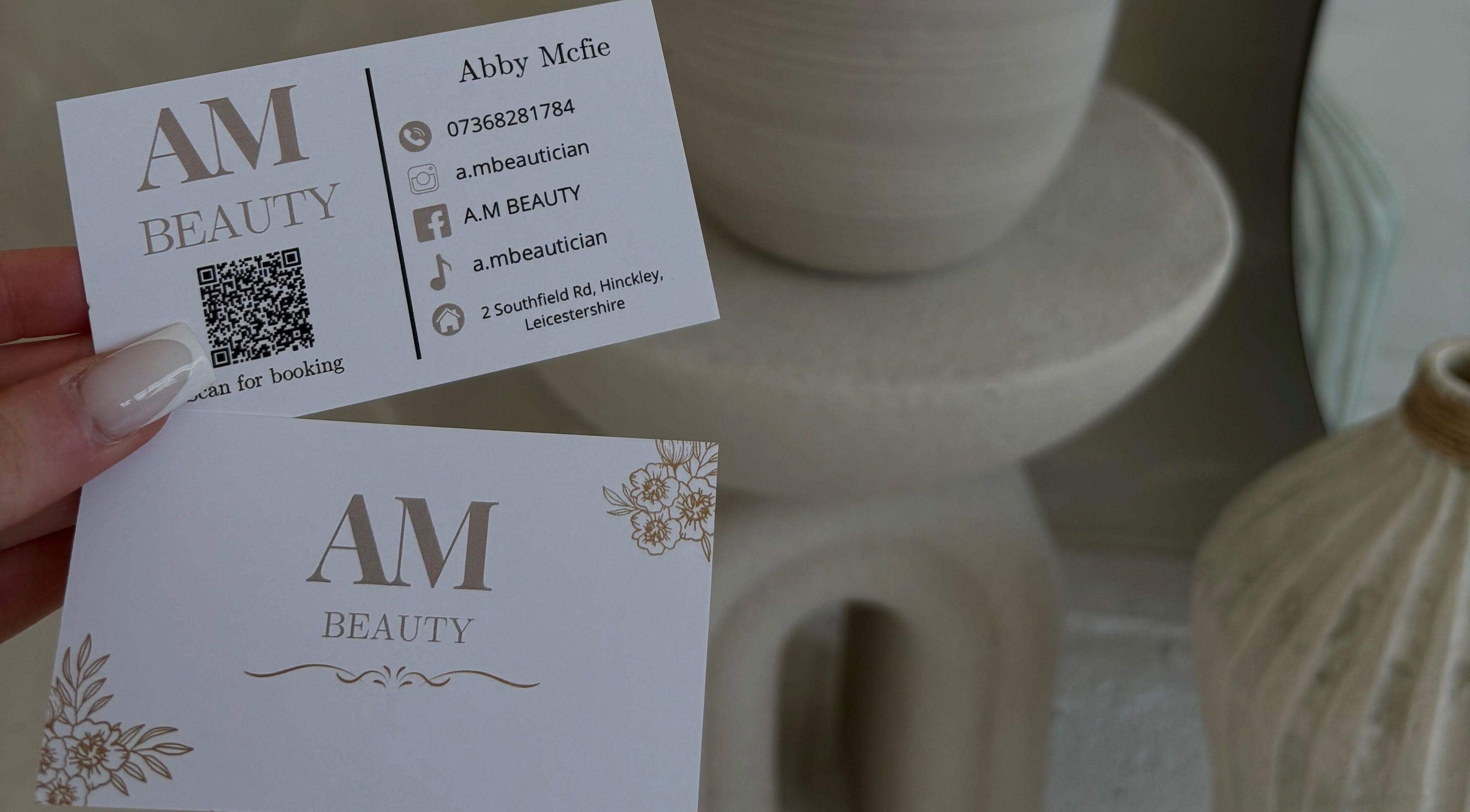 A.M Beauty business cards in Hinckley, England, GB featuring contact details and floral design.