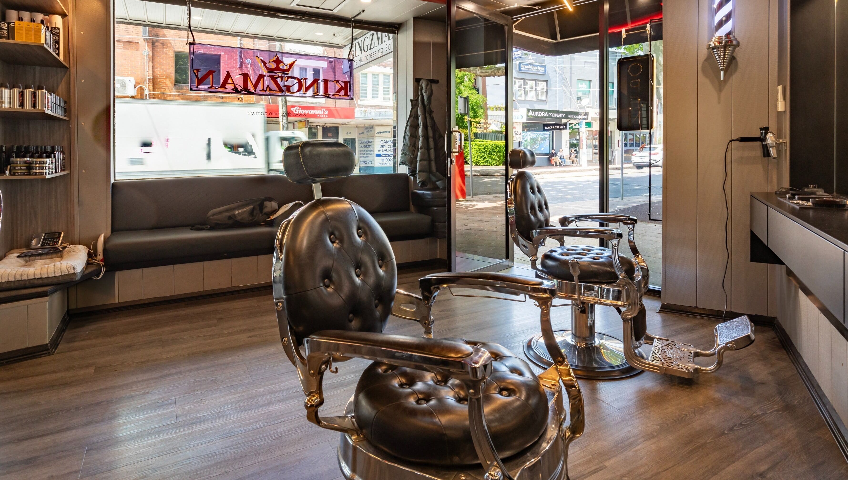Stylish interior of KINGZMAN barbershop in Cammeray, NSW, AU with vintage chairs and modern decor.