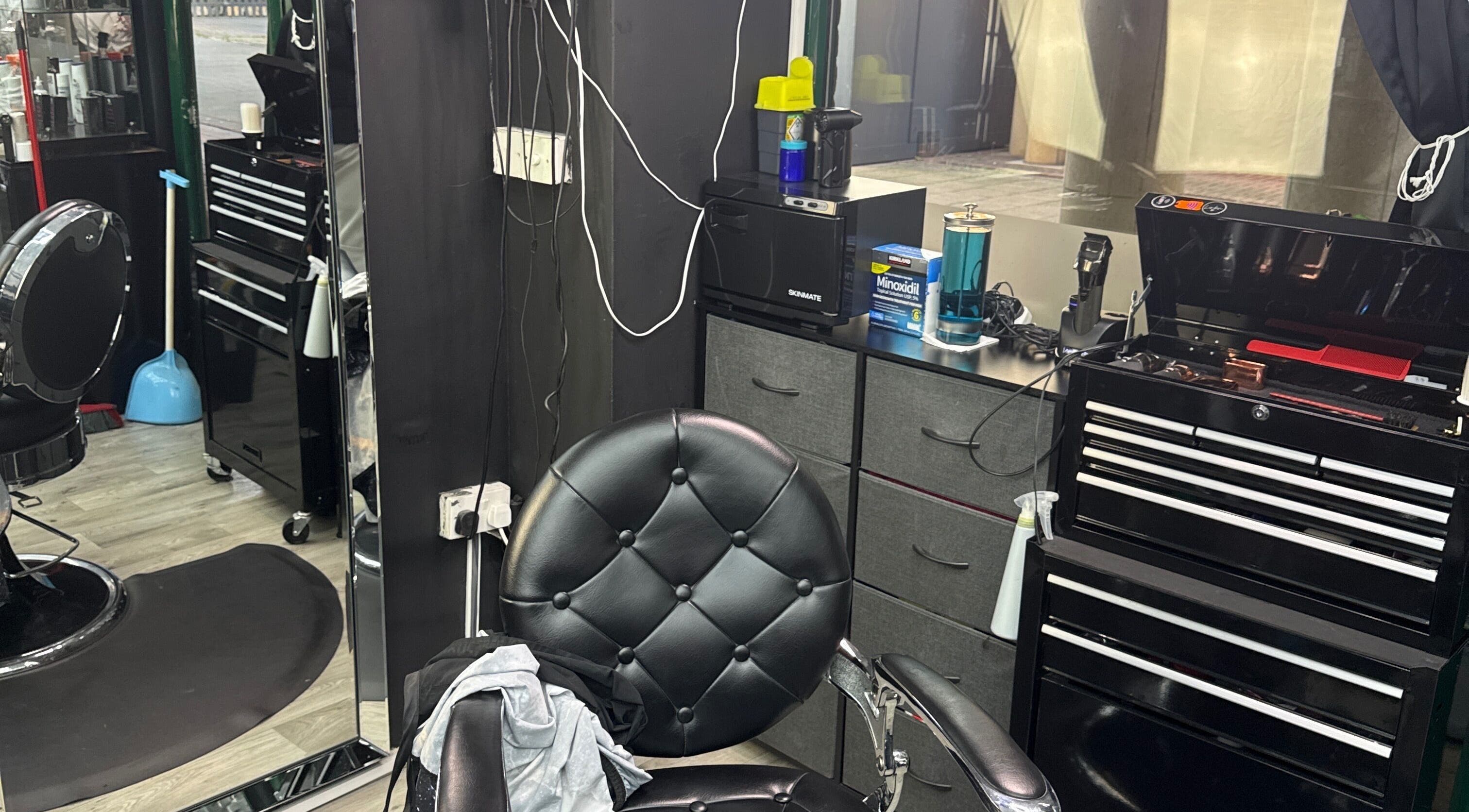 Interior elegante de White Lion Barber en Londres, Inglaterra, GB, mostrando silla de barbería y herramientas.