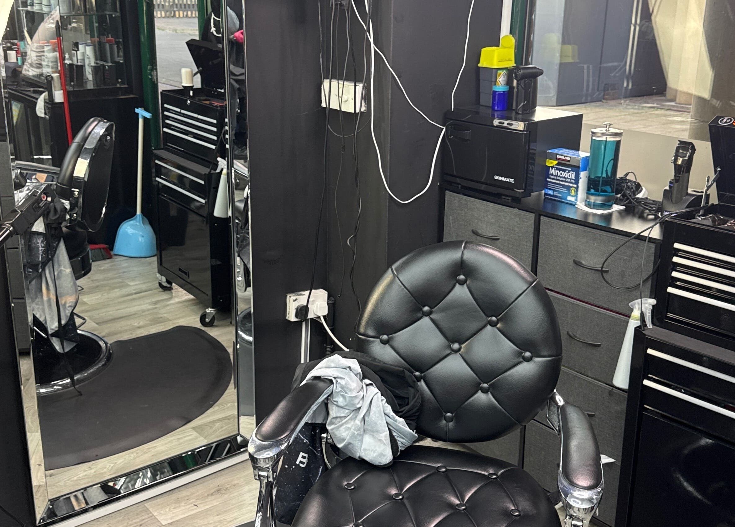 Silla negra en White Lion Barber, Londres, Inglaterra, GB con espejo y herramientas de peluquería.