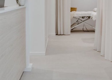 Calming treatment room at E&B Aesthetics Marbella, Malaga, Andalucía, ES with soft curtains and massage table.