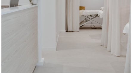 Calming treatment room at E&B Aesthetics Marbella, Malaga, Andalucía, ES with soft curtains and massage table.