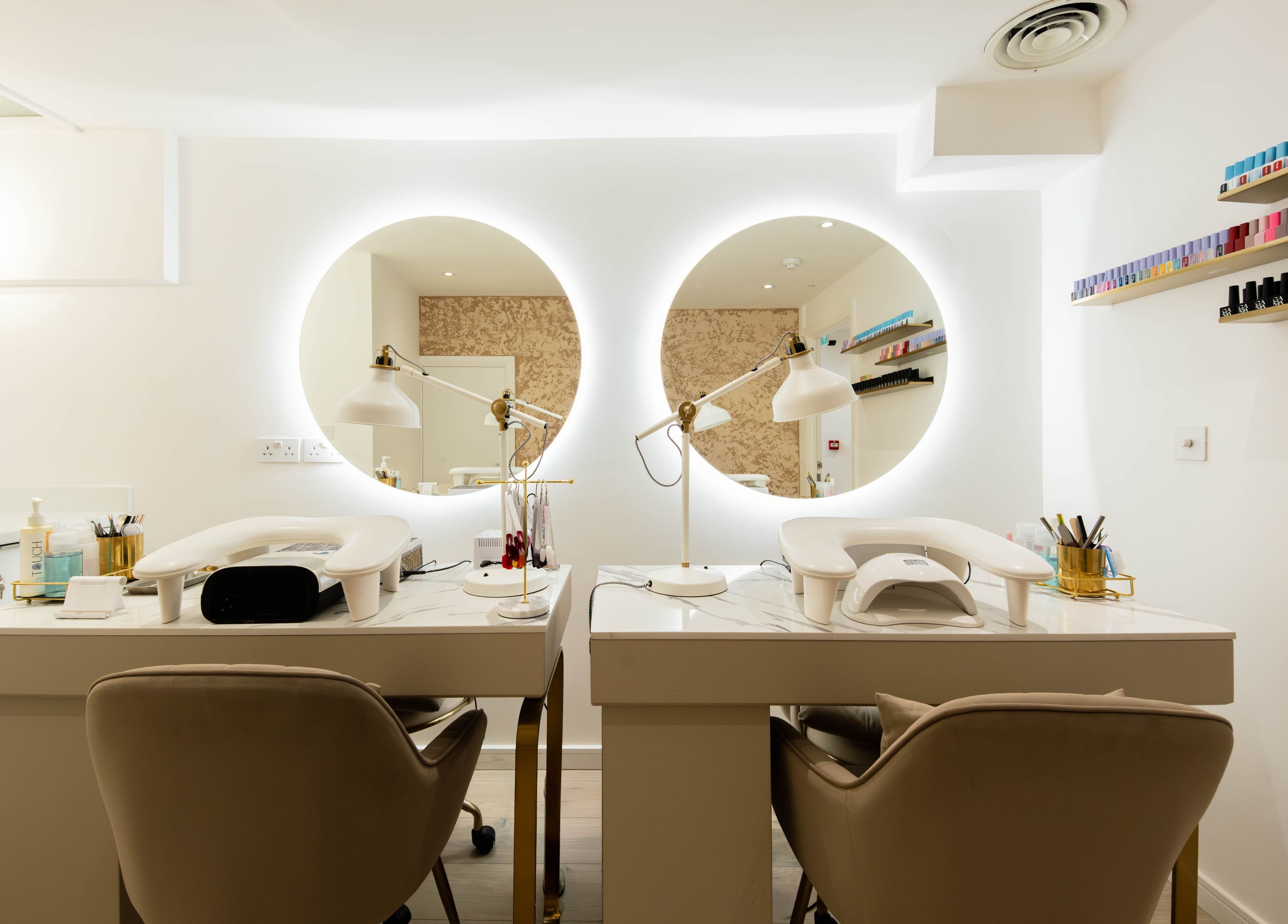 Beauty Stories Fulham nail station interior in London, England, GB, with elegant dual workstations and circular mirrors.