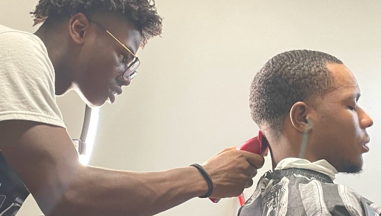 Barber crafting a precise haircut at Jesus in da Cut ™️, Berrien Springs, Michigan, US.