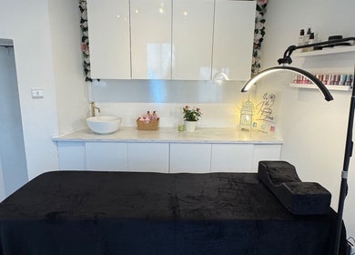 Relaxing treatment room at Infinity Brows in Poole, England, GB, featuring a sleek massage table and modern decor.