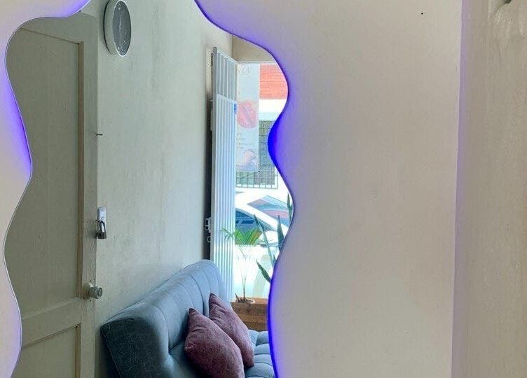 Elegante sala de espera en Cataleya estética y spa, Fusagasugá, Cundinamarca, CO con espejo iluminado.