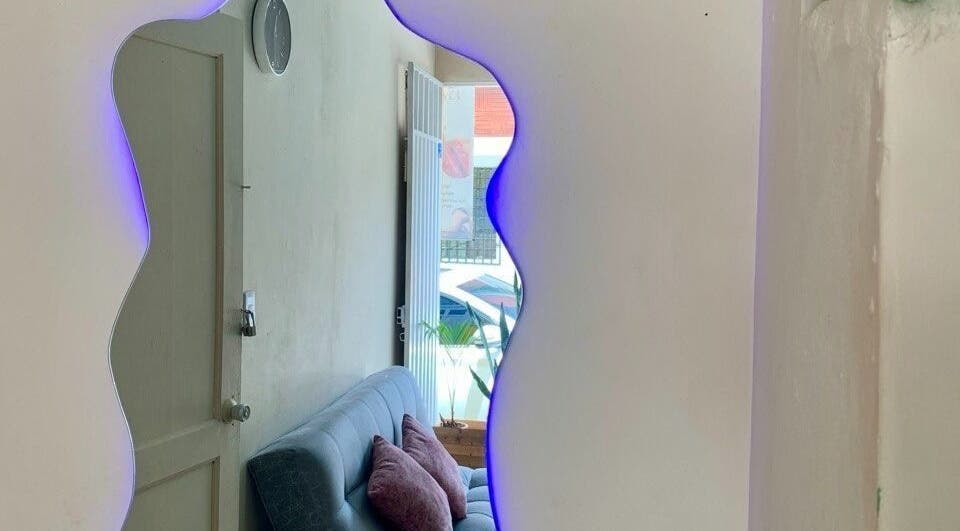 Elegante sala de espera en Cataleya estética y spa, Fusagasugá, Cundinamarca, CO con espejo iluminado.