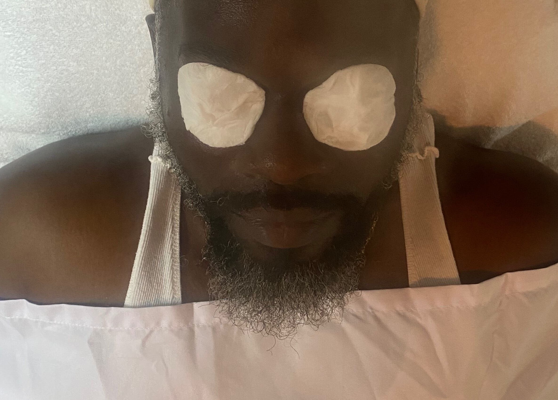 Man enjoying facial treatment at SkinDeep in Nassau, New Providence, BS for ultimate relaxation.